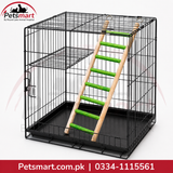 A black metal wire pet crate with a black plastic tray, featuring a wooden ladder with green plastic steps. The Petsmart logo is visible in the top-left corner, and a red banner with contact details is at the bottom.